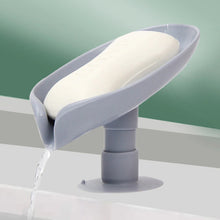 Self-draining soap holder in leaf shape for bathroom or kitchen.